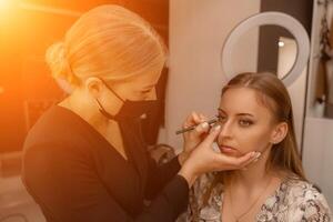 bilden Künstler Farben Wimpern zu ein Frau im ein Schönheit Salon. foto