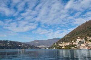 Lago di wie. schön Aussicht von das See von como gegen Alpen Berge und Blau wolkig Himmel Hintergrund auf ein sonnig Winter Tag im das Provinz von Mailand im Lombardei, Italien. wunderbar Reise Ziele foto