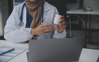 abgeschnitten Aussicht von Arzt im Weiß Mantel halten Flasche Medikament, verschreiben Tabletten zu krank geduldig über online Beratung. Familie Therapeut empfehlen Qualität Medikamente. Gesundheitspflege, Behandlung Konzept foto