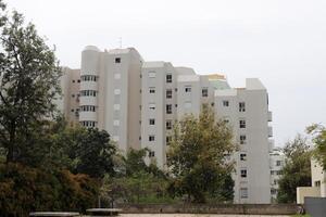 Gebäude und Strukturen im tel aviv gegen das Hintergrund von Geäst und Blätter von hoch Bäume. foto