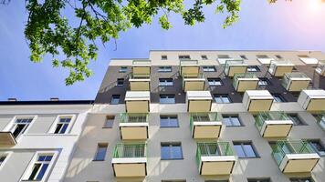 modern Wohn Gebäude mit Neu Wohnungen im ein Grün Wohn Bereich. Öko die Architektur. Grün Baum und Neu Wohnung Gebäude. das Harmonie von Natur und Modernität. foto