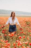 glücklich Frau im ein Mohn Feld im ein Weiß Hemd und Denim Rock mit ein Kranz von Mohnblumen auf ihr Kopf posieren und genießen das Mohn Feld. foto