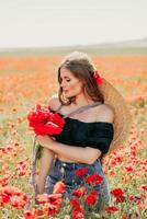 Frau Mohnblumen Feld. Porträt glücklich Frau mit lange Haar im ein Mohn Feld und genießen das Schönheit von Natur im ein warm Sommer- Tag. foto