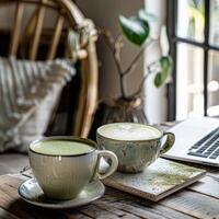 ein Matcha Cappuccino auf ein Arbeit Tabelle im ein Boho-Stil Büro foto