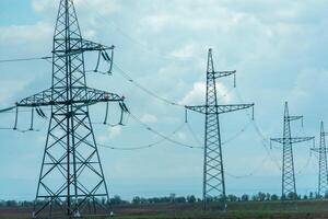 hoch Stromspannung Türme mit Himmel Hintergrund. Leistung Linie Unterstützung mit Drähte zum Elektrizität Übertragung. hoch Stromspannung Gitter Turm mit Draht Kabel beim Verteilung Bahnhof. Energie Industrie, Energie Speichern foto