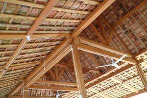 das Dach von ein einfach Gebäude, das Rahmen ist gemacht von Holz. Dach Fliesen sind gemacht von Lehm foto