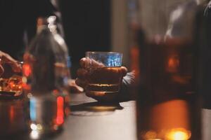 Feier Nacht, gießen Whiskey in ein Glas. geben zu freunde Wer Kommen Sie zu feiern foto