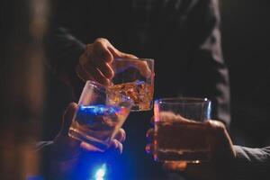 Feier Nacht, gießen Whiskey in ein Glas. geben zu freunde Wer Kommen Sie zu feiern foto