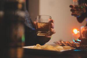 Feier Nacht, gießen Whiskey in ein Glas. geben zu freunde Wer Kommen Sie zu feiern foto