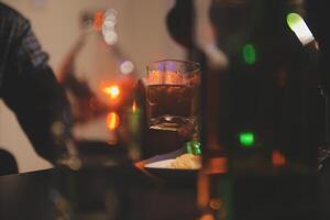 Feier Nacht, gießen Whiskey in ein Glas. geben zu freunde Wer Kommen Sie zu feiern foto