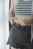 Frauen Körper Fett Bauch. fettleibig Frau Hand halten übermäßig Bauch fett. Diät Lebensstil Konzept zu reduzieren Bauch und gestalten oben gesund Bauch Muskel. foto