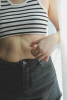 Frauen Körper Fett Bauch. fettleibig Frau Hand halten übermäßig Bauch fett. Diät Lebensstil Konzept zu reduzieren Bauch und gestalten oben gesund Bauch Muskel. foto
