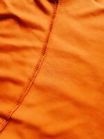 Orange Stoff Hintergrund, seidig Gradient Luxus Stoff Textur, Sommer- Textil- Banner Material tropisch Welle aussehen Mode abstrakt Design Poster Vorlage foto