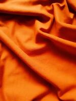 Orange Stoff Hintergrund, seidig Gradient Luxus Stoff Textur, Sommer- Textil- Banner Material tropisch Welle aussehen Mode abstrakt Design Poster Vorlage foto