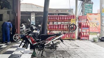 Mechaniker im Overall Herstellung Diagnose von Motorrad in der Nähe von Werkzeugkasten im Werkstatt. Jakarta, Indonesien, kann 1, 2024 foto