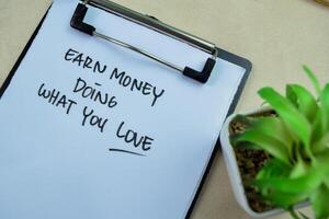 Konzept von verdienen Geld tun Was Sie Liebe schreiben auf Papierkram isoliert auf hölzern Hintergrund. foto