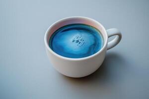 Beliebt Blau Matcha Tee im ein Weiß Tasse auf ein Licht Hintergrund mit Raum zum Text oder Design. Blau Algen Spirulina, Schmetterling Erbse Blume oder Blau Matcha Pulver foto