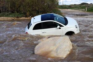 das Auto war getragen Weg durch ein stark Regen fließen von Wasser. foto