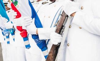 Marinesoldaten mit Handschuhe im das Hände halten ein Gewehr und Flaggen. foto