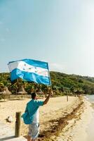 ein Person halten und winken Honduras Flagge im ein Strand. Patriotismus Konzept. foto