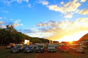 Nakhonratchasima, Thailand - - Dezember 26, 2023 viele alt klassisch Mini Austin Cooper geparkt auf Gras Feld mit Grün Baum und klar Blau Himmel Hintergrund beim khao Ja, Nakhonratchasima, Thailand foto