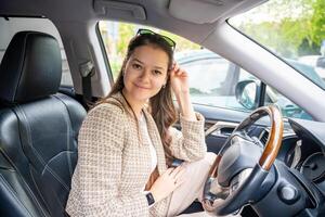 Porträt von jung Frau Innerhalb Auto Innere. das Auto wie ein Platz im welche ein von Bedeutung Teil von Menschen Leben geht vorbei foto