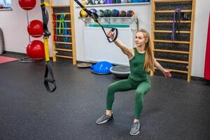 Ausbildung im das Fitnessstudio zum das Zahl Korrektur. jung Frau tun Fitness Übungen beim Fitnessstudio. hoch Qualität Foto