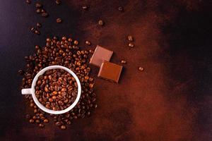 Samen von duftendem Kaffee auf dunklem Betonhintergrund foto