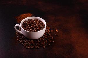 Samen von duftendem Kaffee auf dunklem Betonhintergrund foto