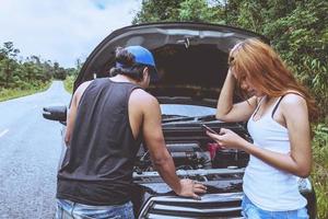 asiatische Frauen- und Männerliebhaber reisen im Urlaub entspannen. kaputtes Auto auf der Straße. Thailand foto