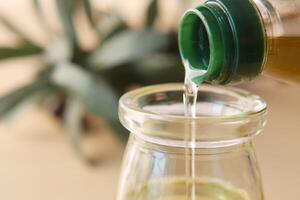 Gießen natürlich Olive Öl von ein Flasche foto