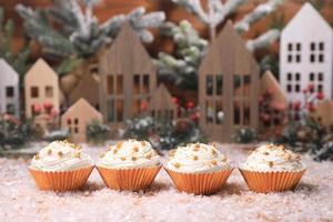 Feiertagsweihnachtscupcakes auf saisonalem Hintergrund foto