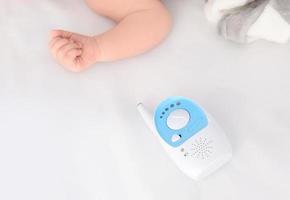 Babyphone und schlafendes Kind auf dem Bett. Radio-Kindermädchen foto