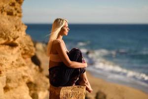 Frau genießt den Sonnenuntergang an einem schönen Strand foto