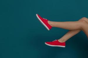 Beine der schönen Frau in stilvollen Schuhen auf farbigem Hintergrund foto