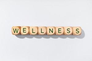 Wellness-Wort in Holzklötzen auf grauem Hintergrund isoliert