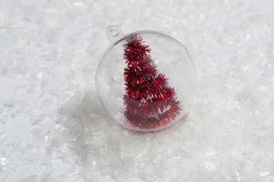 Weihnachtsbaum in einer transparenten Kugel im Schnee. minimales Konzept der Postkarte, Einladungskarte. Nahaufnahme foto