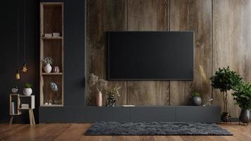 Mockup einer TV-Wand, die in einem dunklen Raum mit einer dunklen Holzwand montiert ist. foto