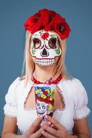 blonde Frau in Santa Muerta-Maske. foto
