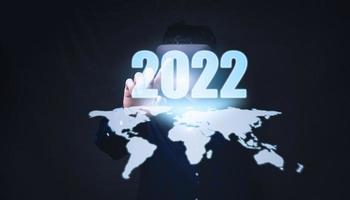 Menschen zeigen auf Zahlen, Hologramme, Jahr 2022 foto