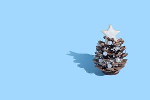 Kreativer Tannenzapfen-Weihnachtsbaum im skandinavischen Stil. Neujahrskarte mit Textfreiraum