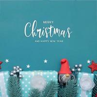 Frohe Weihnachten-Grußkarte mit flachen Winterferien Dekorationen auf türkisfarbenem Hintergrund foto