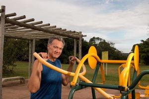 Älterer reifer Mann, der in einem Outdoor-Fitnesspark im Parque das Garcas, Brasilia, trainiert? foto