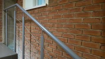 rotes Backsteingebäude mit moderner Treppe im Loft-Stil mit Metallgeländer. Treppen schmücken das Gebäude. modernes Treppenhaus. Geländer aus Stahl. Treppe perspektivisch. foto