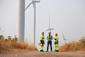 Spezialist Wind Turbine Mannschaft von Ingenieure diskutieren Grün Energie Produktion im Wind Turbinen Bauernhof oder Windmühlen Feld. Mannschaft von Ingenieur Energie Planung Aktivität im Windmühlen industriell Bereich foto