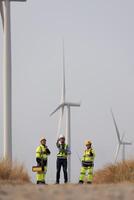 Spezialist Wind Turbine Mannschaft von Ingenieure diskutieren Grün Energie Produktion im Wind Turbinen Bauernhof oder Windmühlen Feld. Mannschaft von Ingenieur Energie Planung Aktivität im Windmühlen industriell Bereich foto