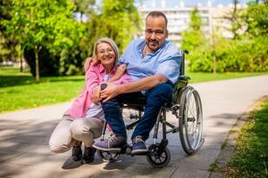 Mann im Rollstuhl ist Ausgaben Zeit mit seine Freund im Park. foto