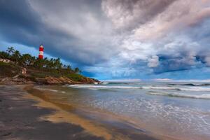 Versammlung Sturm auf Strand und Leuchtturm auf Sonnenuntergang. Kerala, Indien foto