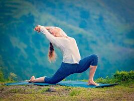 sportlich passen Frau Praktiken Methoden Ausübungen Yoga Asana anjaneyasana im Berge foto