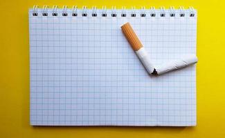 Welt kein Tabaktag, kein Rauchertag. kaputte Zigarette auf einem Business-Notizbuch, Platz für Ihren Text foto